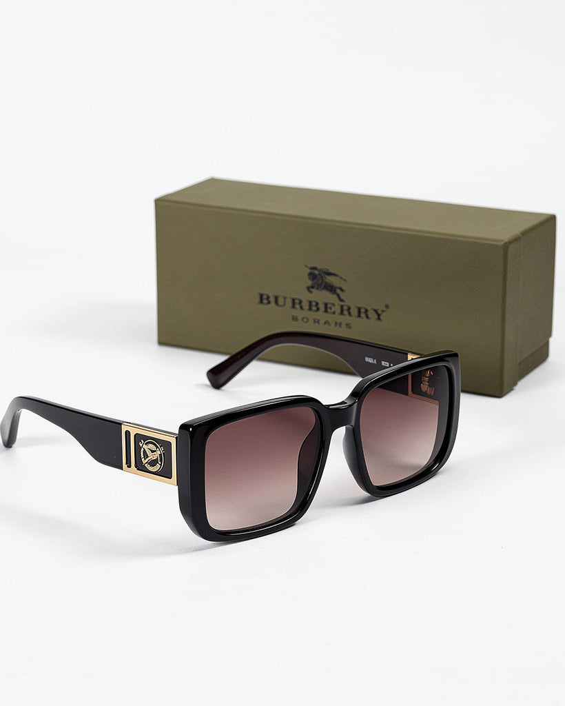 Black sunglasses with gold accents in front of a Burberry box on a white background