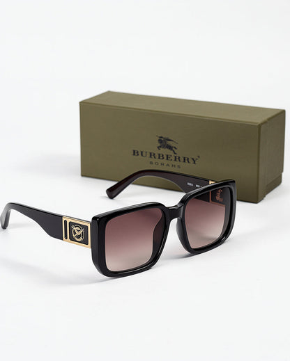 Black sunglasses with gold accents in front of a Burberry box on a white background