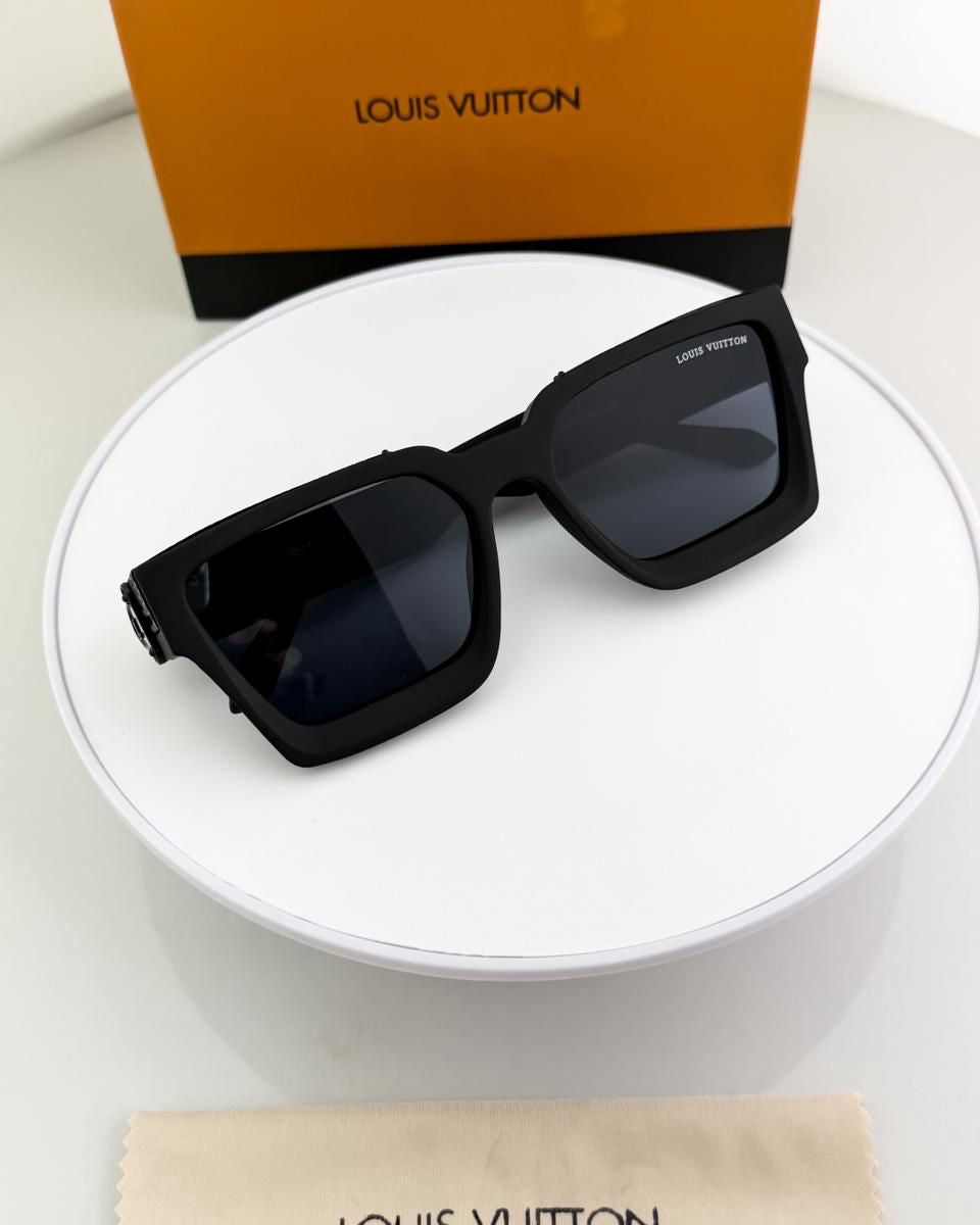 Black sunglasses with Louis Vuitton packaging on a white surface