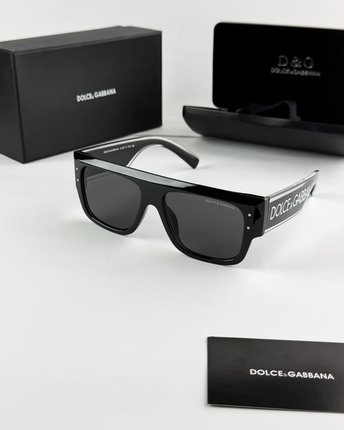 Black Dolce & Gabbana sunglasses with packaging on a white background