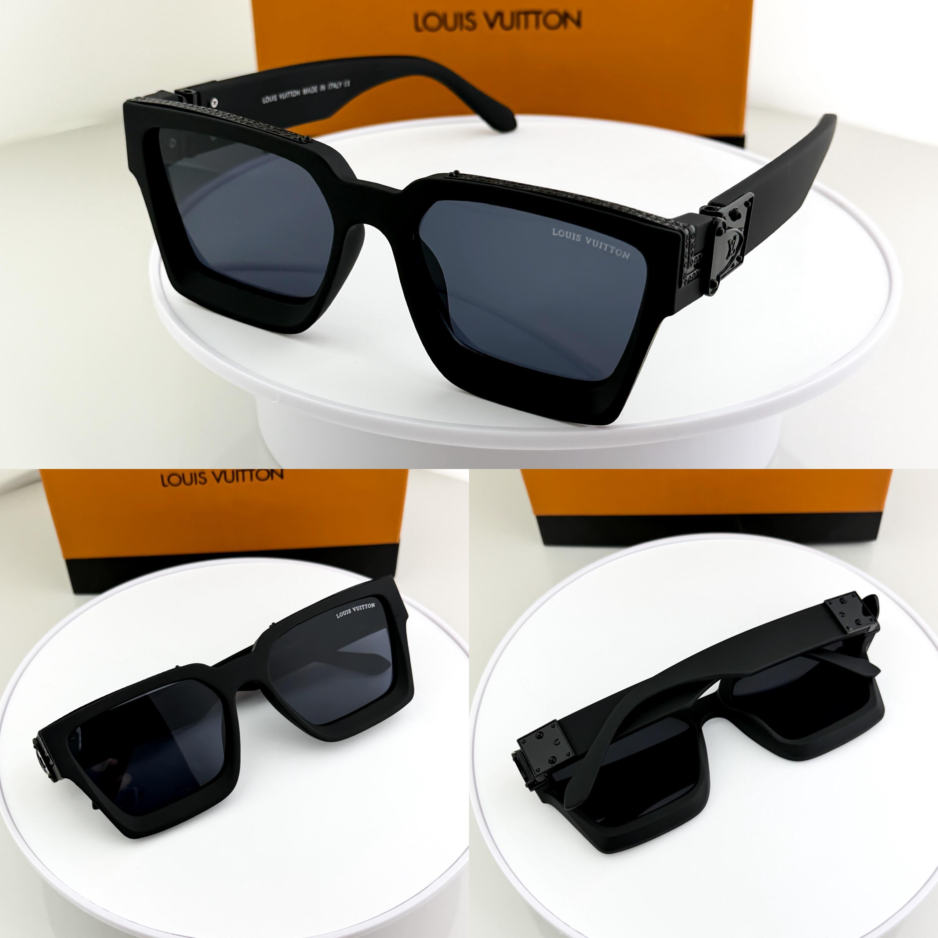 Black sunglasses on a white stand with Louis Vuitton boxes in the background