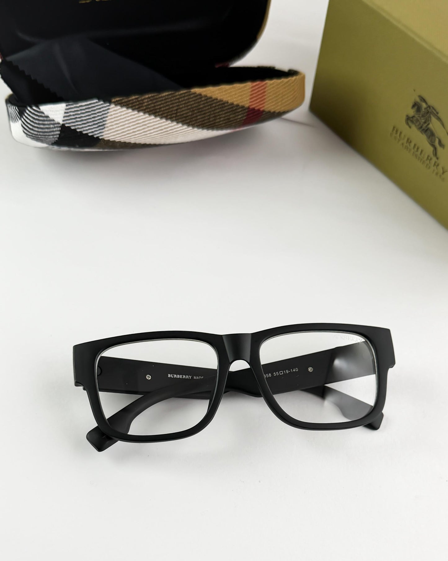 Black glasses with Burberry logo on a white surface