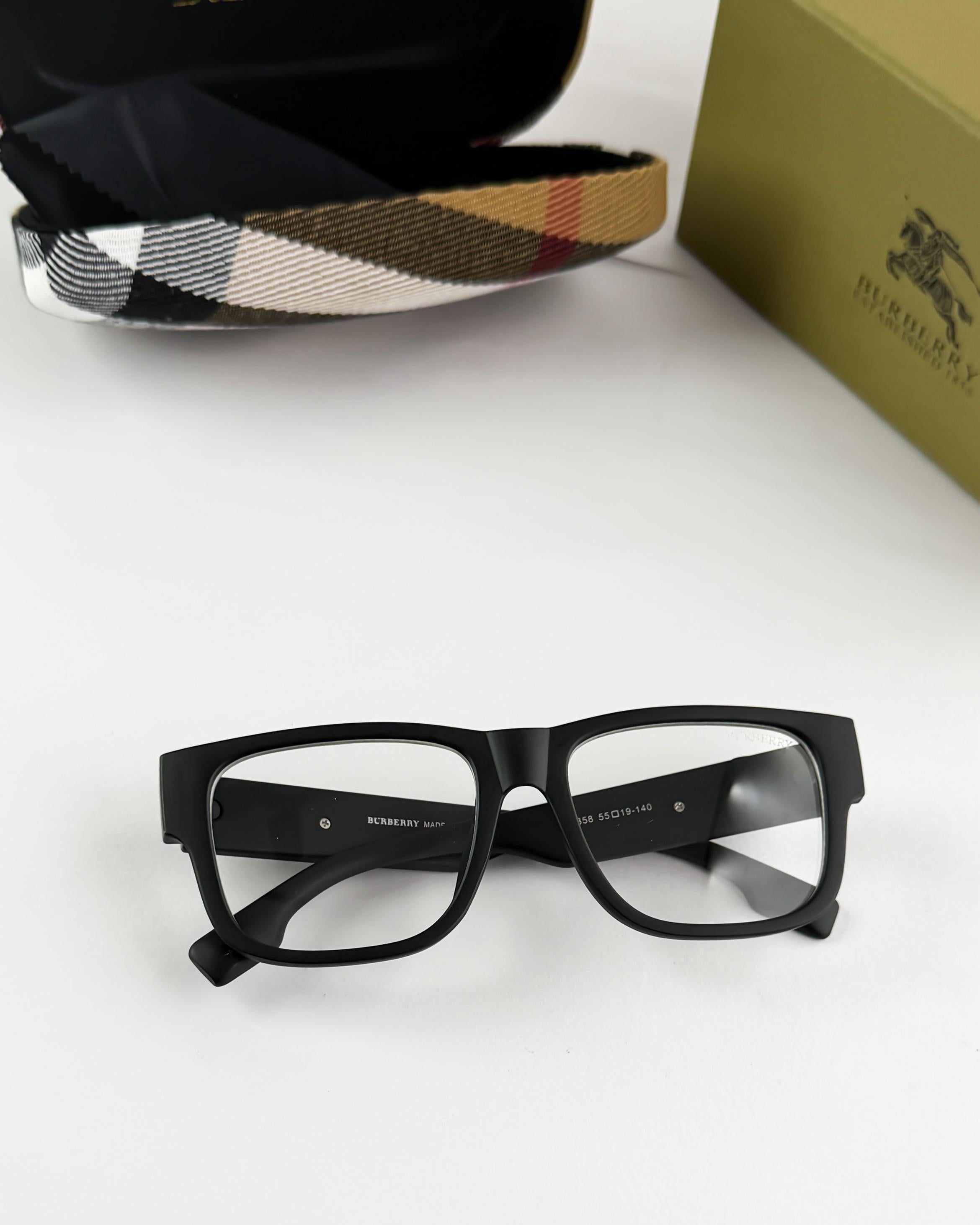Black glasses with Burberry logo on a white surface