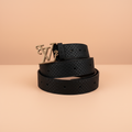 Black textured belt on a peach table, right angle