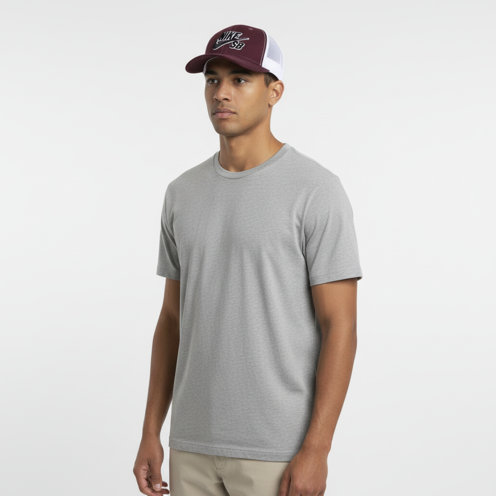 Male model wearing maroon and white mesh trucker cap in white studio